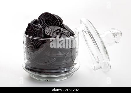 Schwarze Lakritzspiralen, Kaubonbons und köstliches Dessertkonzept mit Lakritzrädern, die mit dem Extrakt der Wurzel des Glycyr aromatisiert werden Stockfoto