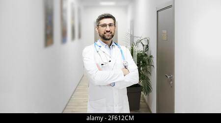 Portrait eines gut aussehenden reifen Hausarztes mit Phonendoskop in der Moderne Klinikkorridor Stockfoto