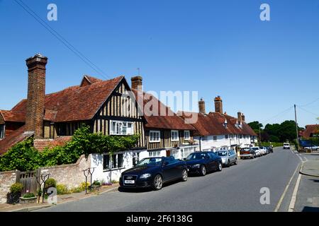 Typisches Fachwerk gerahmtes und kebbleddash Haus und weiß verwittertes Häuschen neben der Hauptstraße durch Dorf, Hartfield, East Sussex, England Stockfoto