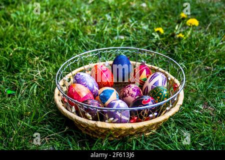 Defokussieren Sie bunte ostereier. Dekoriert pysanka und krashanka. Holzkorb Mit Ostereiern Im Grünen Gras. Nahaufnahme. Festlich. Traditionell. Stockfoto
