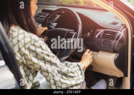 Frau starten Motor des Autos drehen Schlüssel. Stockfoto