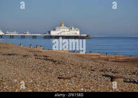 Eastbourne Stoney Beach mit Blick auf Eastbourne Pier auf EINEM sonnigen Winter Day - Blauer Himmel Und Ruhiges Meer - Holz Groynes English Channel - Sussex UK Stockfoto