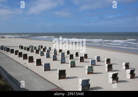 Wangerooge, Deutschland. März 2021, 29th. Die ersten Strandliegen am Bade- und Schlossstrand der ostfriesischen Insel stehen bei schönstem Sonnenschein nebeneinander. Sie können von Einheimischen und Zweitwohnern gemietet werden. Für Tagestouristen macht jedoch ein Ausflug nach Wangerooge wegen der Gezeitenabhängigkeit der Fähren zur Zeit, während der Corona-Pandemie, kaum Sinn. Quelle: Peter Kuchenbuch-Hanken/dpa/Alamy Live News Stockfoto