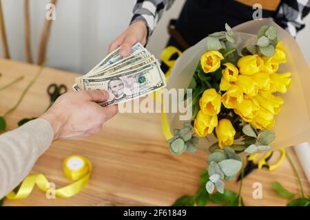 Frau Floristin verkauft Blumen an einen Mann Stockfoto