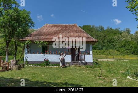 Salaj, Transsilvanien, Rumänien-14. Mai 2018:altes Paar, Mann und Frau in traditioneller rumänischer Tracht, die Hände vor ihrem charmanten Hous weben Stockfoto