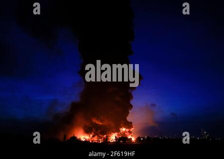 Indramayu, Indonesien. März 2021, 29th. Rauchentwicklung und massiver Brand aus einer Ölraffinerie des staatlichen Öl- und Gasunternehmens PT Pertamina in Balongan, Indramayu, West Java, Indonesien, am 29. März, 2021. Drei Menschen wurden vermisst und 19 weitere wurden verletzt, fünf von ihnen erlitten schwere Verletzungen, und fast 1.000 Bewohner in der Nähe wurden nach einem massiven Brand in einer Ölraffinerie in Indonesiens Provinz West-Java nach Mitternacht am Montag evakuiert, sagten Beamte. Quelle: Wiralandra/Xinhua/Alamy Live News Stockfoto