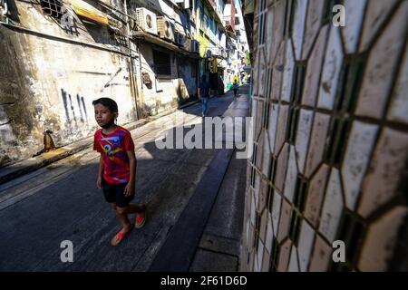 Ein Junge läuft in Talat Noi, Bangkok, Thailand, entlang einer Gasse Stockfoto