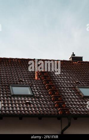 Ein gefliestes Dach mit Stufen, die zum Kamin führen Ein kalter Wintermorgen Stockfoto