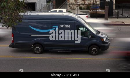 Los Angeles, CA / USA - 25. März 2021: Ein Amazon Prime Lieferwagen wird in einem Median geparkt angezeigt, da Autos auf beiden Seiten entlang einer Stadtstraße vorbeifahren. Stockfoto