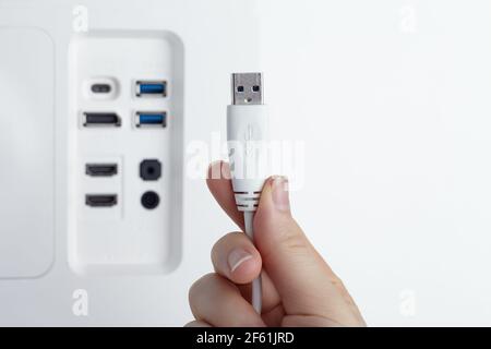 Nahaufnahme des USB3-Kabels in einer Frauenhand. Der integrierte USB-Hub des Monitors als Backgound Stockfoto