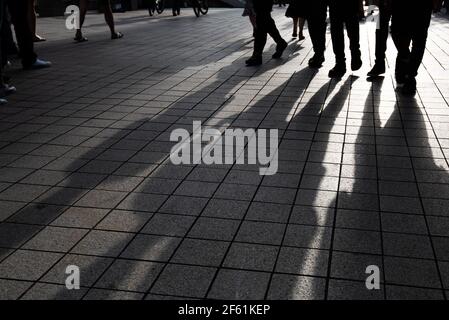 Silhouette von unerkannten Menschen, die auf der Straße spazieren. Stockfoto