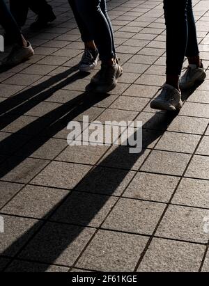 Silhouette von unerkannten Menschen, die auf der Straße spazieren. Stockfoto