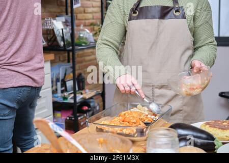 Nicht erkennbare junge Frau Kochen gefüllte Auberginen. Garzeit. Stockfoto