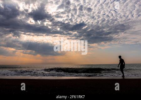Am frühen Morgen an einem Strand mit Silhouetten Figur. Stockfoto