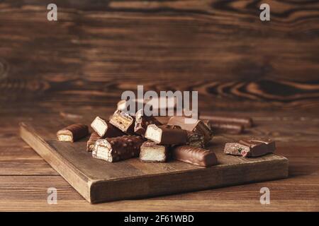 Süße Schokoriegel auf Holzhintergrund Stockfoto