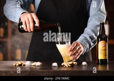 Der Barkeeper gießt frisches Ingwerbier in ein Glas auf dem Tisch Bar Stockfoto