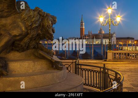 Bronze venezianischen Löwen mit Blick auf San Giorgio Maggiore und Bacino San Marco auf der Statue von Victor Emmanuel II, Castello, Venedig, Italien, bei Nacht Stockfoto