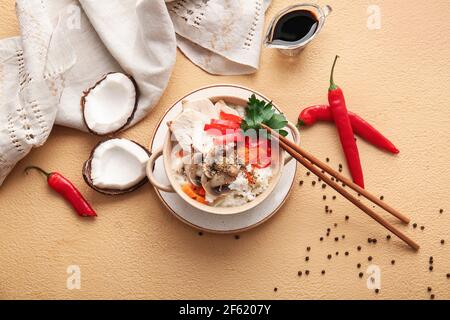 Kochtopf mit thailändischer Hühnerreis-Suppe auf farbigem Hintergrund Stockfoto