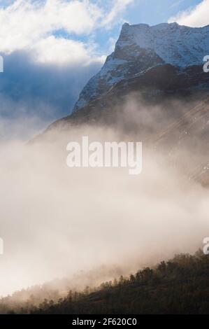 Berg mit frischem Schnee über Nebel Stockfoto