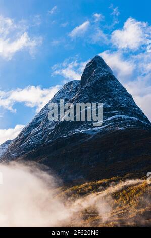 Berg mit frischem Schnee über Nebel Stockfoto