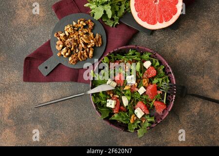 Schüssel mit Rucola-Salat auf dem Grunge-Tisch Stockfoto