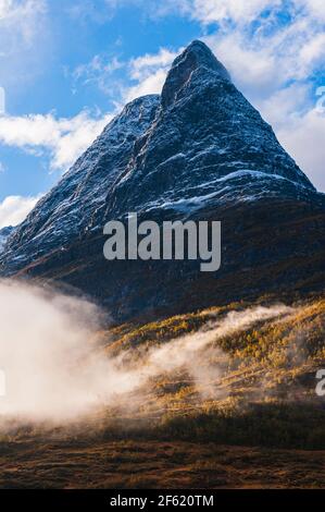 Berg mit frischem Schnee über Nebel Stockfoto