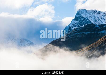 Berg mit frischem Schnee über Nebel Stockfoto