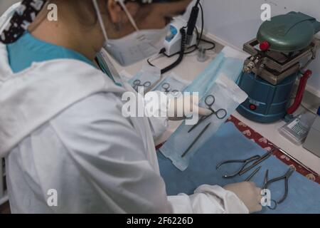Krankenschwester verpackt ein zahnmedizinisches Instrument vor seiner Sterilisation in einem Zahnklinik - Konzept der modernen Technologie in der Medizin Stockfoto
