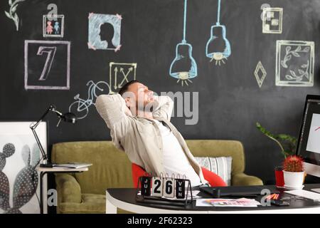 Männlicher Designer mit Pause während der Arbeit im Büro Stockfoto