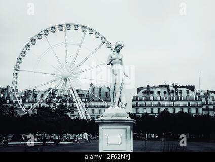 Griechische Statue und ein Riesenrad im Tuilerien-Garten in Paris Stockfoto