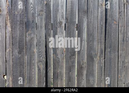 Ein grauer Holzzaun mit ausgeprägter knottiger Textur und rauer Oberfläche, mit rostigen Nägeln genagelt. Eine hohe Auflösung. Stockfoto