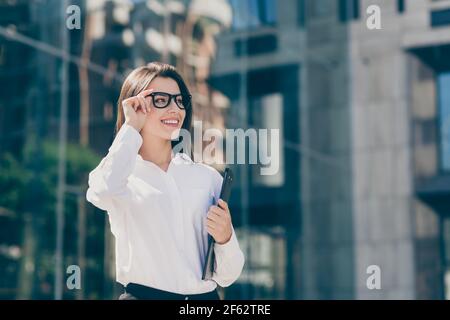 Foto von jungen schönen attraktiven schönen lächelnd fröhlich Geschäftsfrau in Brillen halten Organizer gehen draußen im Freien Stockfoto