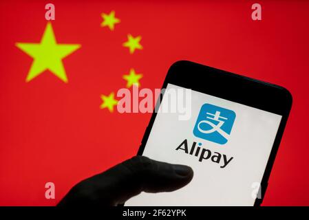 In diesem Foto Illustration die chinesische Online-Zahlungsplattform von Alibaba Group gehört, Alipay-Logo auf einem Android-Mobilgerät mit Volksrepublik China Flagge im Hintergrund gesehen. Stockfoto