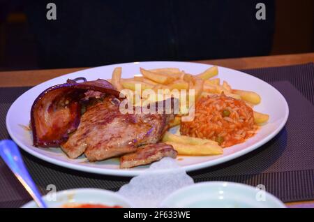 Gegrilltes Fleisch, pommes frites, Reis, Mittagessen in einem Restaurant, Grillplatte Stockfoto