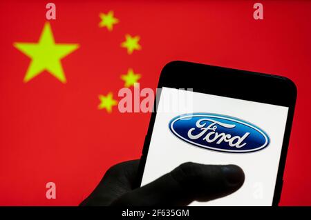 China. März 2021, 27th. In dieser Abbildung zeigt das US-amerikanische multinationale Autohersteller Ford Logo auf einem Android-Mobilgerät mit der Flagge der Volksrepublik China im Hintergrund. Kredit: Budrul Chukrut/SOPA Images/ZUMA Wire/Alamy Live Nachrichten Stockfoto