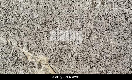 Natürlicher Hintergrund der Stone Granite Wall Nahaufnahme, beige graue Farbe Stockfoto