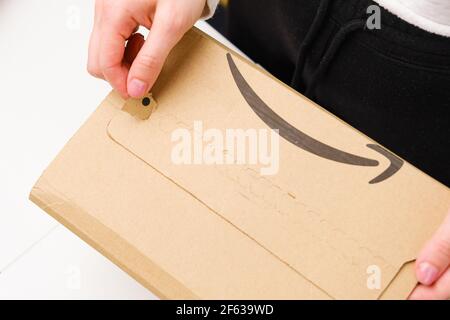 Nahaufnahme Frau Hände öffnet ein Paket von Amazon, März 2021, Prag, Tschechische Republik Stockfoto