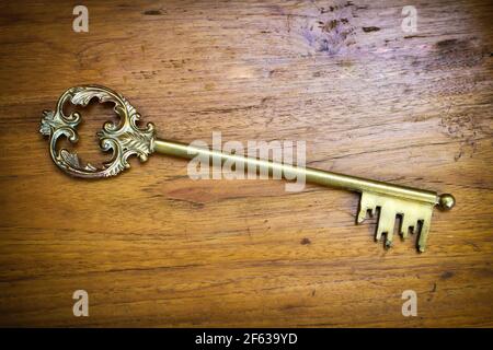 Alte dekorative Vintage Messing Skelett Schlüssel auf einem Holz Hintergrund Betrachtet hoher Winkel mit Copyspace und Seitenvignette Stockfoto