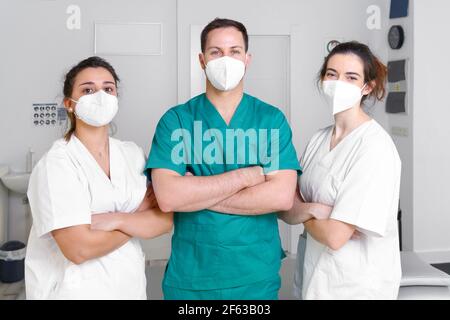 Ein vielfältiges Team von medizinischen Fachkräften trägt eine schützende Gesichtsmaske und arbeitet in einer physischen Rehabilitationsklinik während einer Coronavirus-Pandemie. Hochwertige Fotos Stockfoto