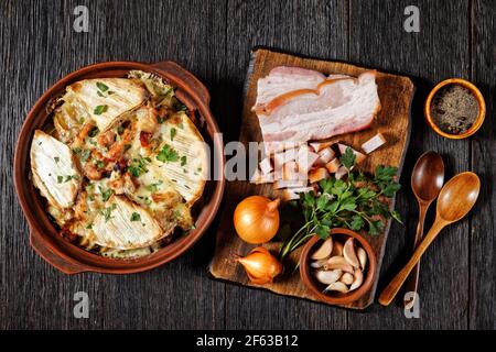 Tartiflette, French Potato, Bacon und Käse Auflauf in einer Tonplatte mit Zutaten auf einem Schneidebrett, flat Lay, französische Küche Stockfoto