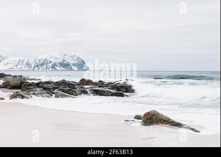 Küstenlandschaft vor schneebedeckten Bergen Stockfoto