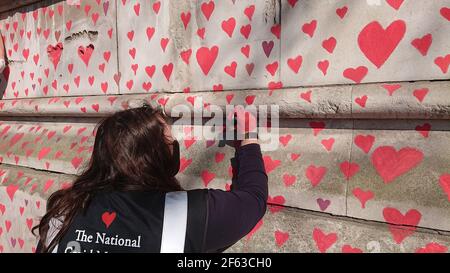 London, Großbritannien. 29th, März 2021. Trauerte Familie und Freunde werden von Keir Starmer besucht, als sie Herzen auf die Covid Memorial Wall malen.