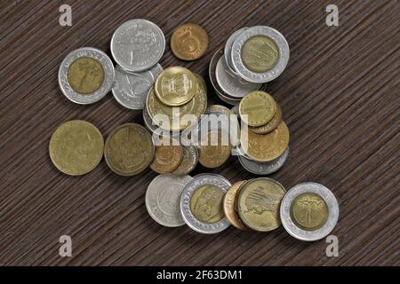 Großer Haufen verschiedener Währungen alte Bronze- und Silbermünzen Auf Holzwerkstofftisch Stockfoto