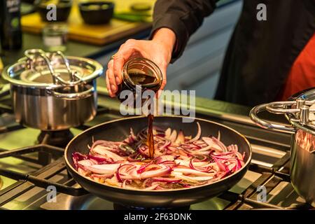 Online-Kochkurs mit Chefkoch Song Lee vom Restaurant Nikkei Nine in Hamburg. Die roten Ponzu Zwiebeln werden mit den typischen japanischen Gewürzzutaten wie Shoyu, Mirin und Reisessig gekocht Stockfoto