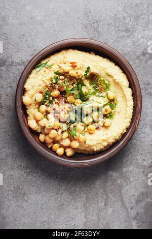 Kichererbsen Hummus in einer Schüssel auf grauem Steingrund. Draufsicht. Stockfoto