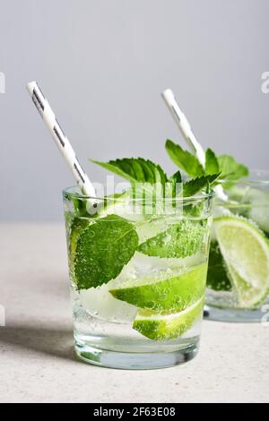 Erfrischendes Trinkglas mit Limette, Minze und Eis, Mojito-Cocktail. Stockfoto