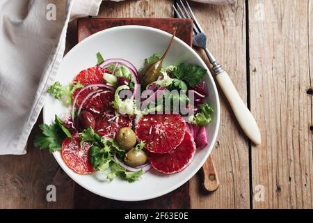 Sizilianischer Orangensalat. Salat mit Blutorange, roten Zwiebeln und Oliven. Stockfoto