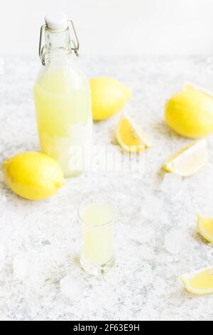 Traditioneller hausgemachter Zitronenlikör Limoncello und frische Zitrusfrüchte auf dem Tisch. Italienisches traditionelles Likörlimoncello mit Zitrone. Italienisches alkoholisches Beve Stockfoto