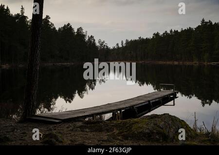 See, Brücke und Wald am Frühlingsabend in Katrineholm Schweden. Schöne skandinavische Natur und Landschaft. Ruhiges, friedliches Foto. Stockfoto