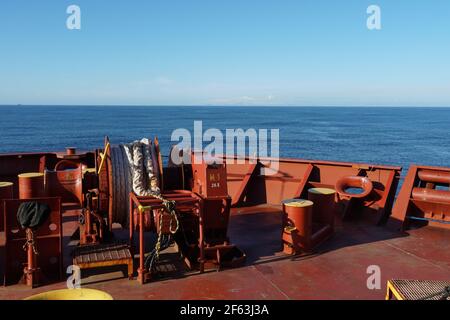 Blick von der Anlegestelle des Frachtschiffes, das über den Pazifischen Ozean zur Insel Aleuten segelt, im Hintergrund mit Schnee bedeckt. Stockfoto